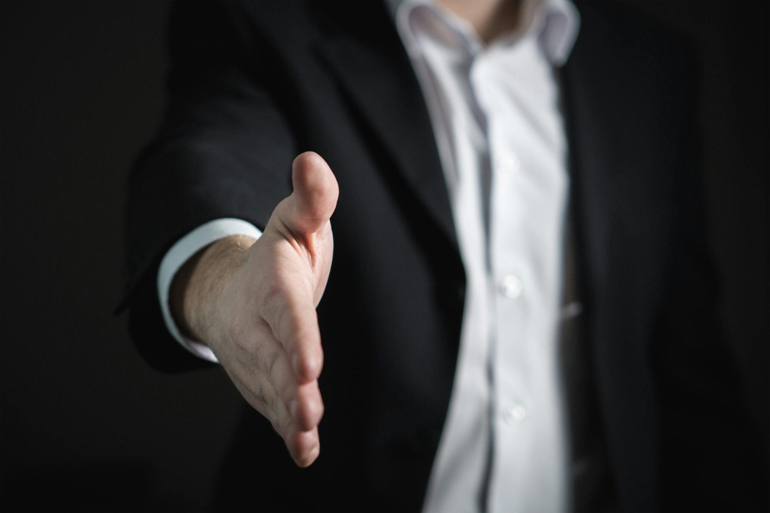 A close up photo of a hand going for a handshake.