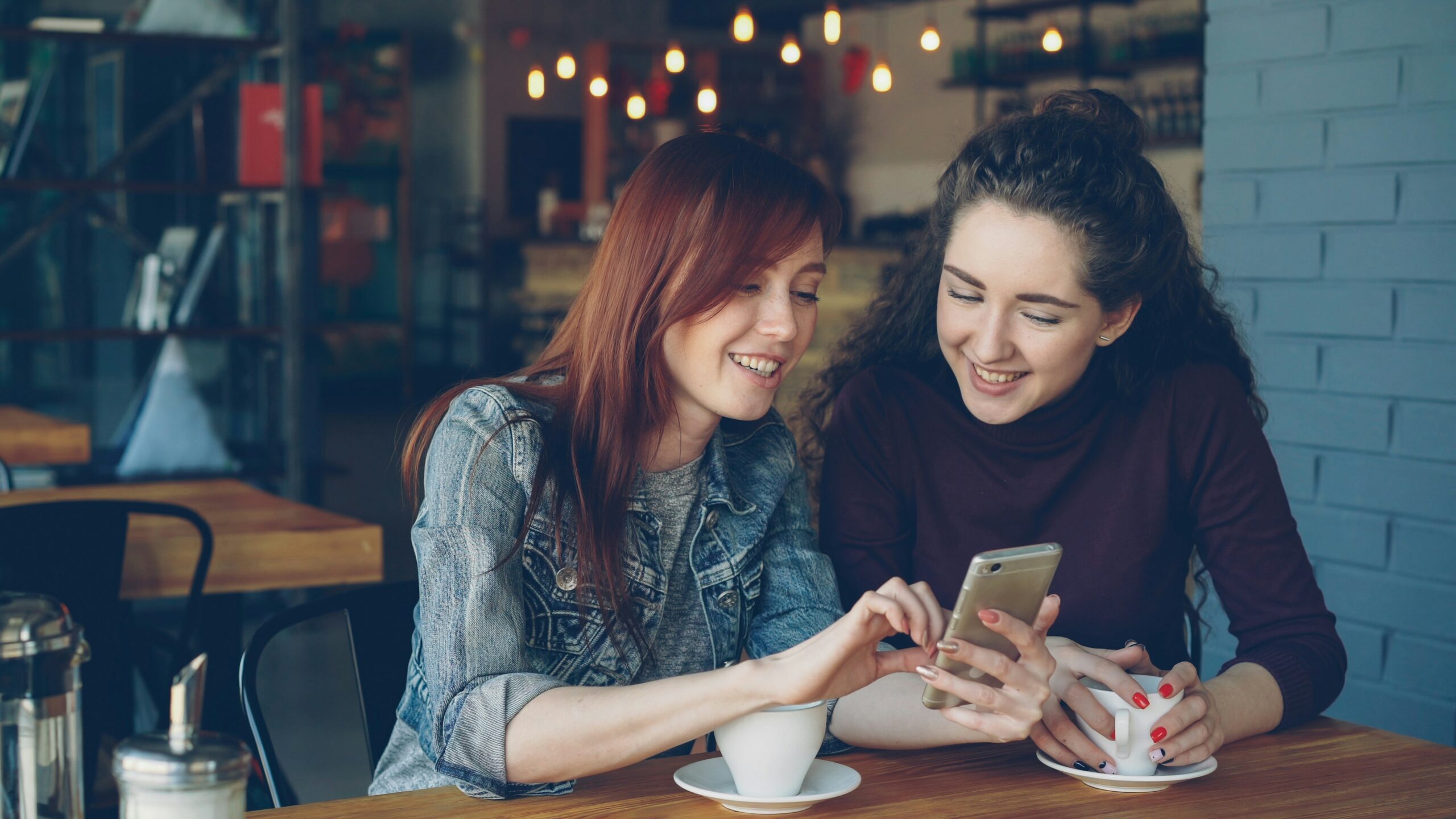 Two women talking about sales campaigns over coffee
